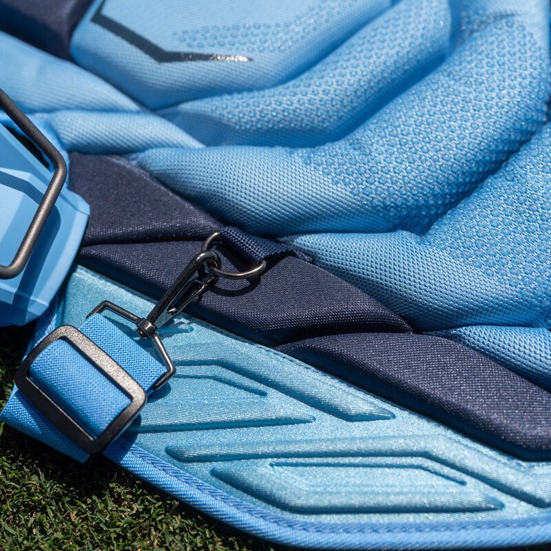 Close-up of light blue Easton Mavrix leg guard strap and buckle detail on chest protector padding