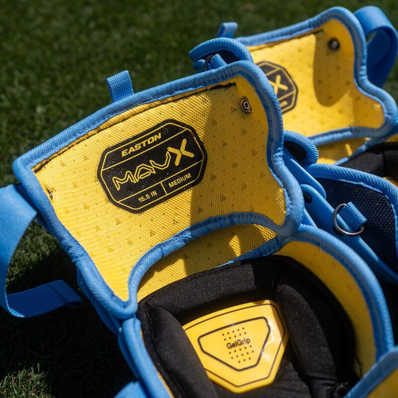 Close-up of yellow Easton Mavrix leg guard knee pads showing embroidered logo and size label